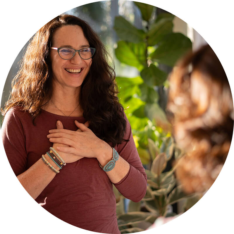 Alara, kids yoga teacher trainer with her hand on her heart teaching yoga to a teenager