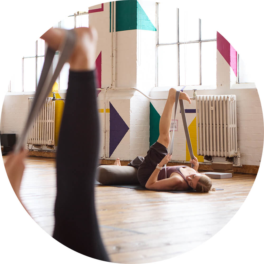 Louise Brown teaching yin yoga: an assisted hamstring stretch at Yogarise Peckham. 